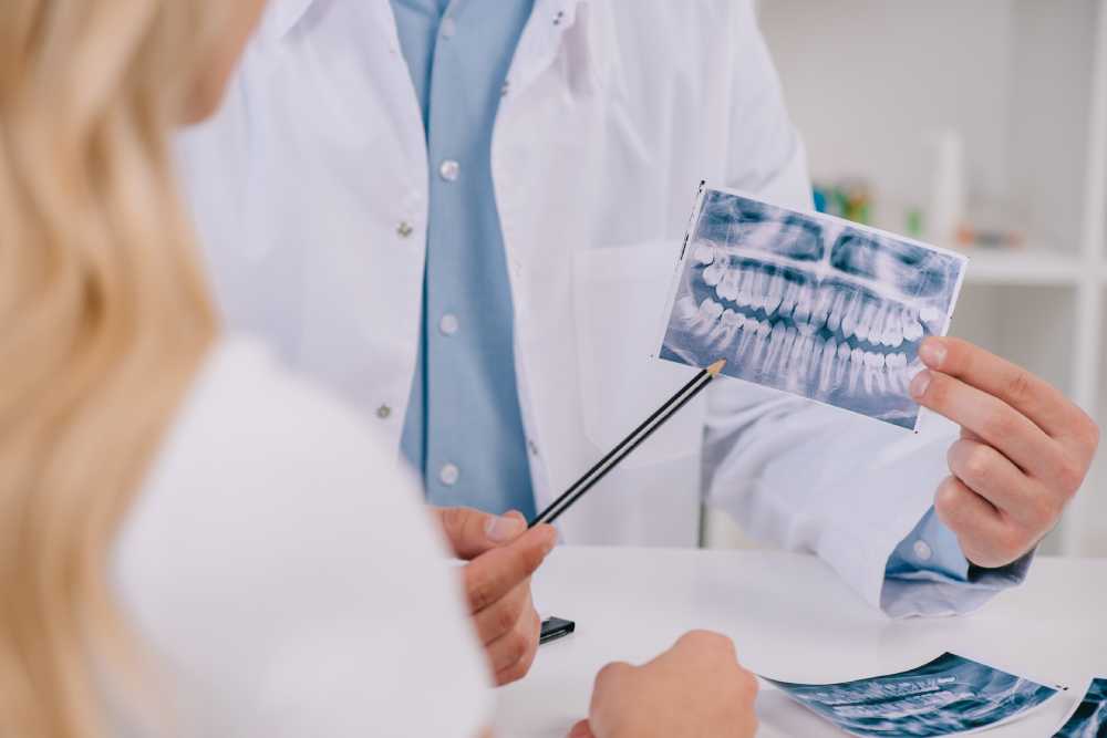 A dentist is showing an x-ray to a dental patient in Kitchener