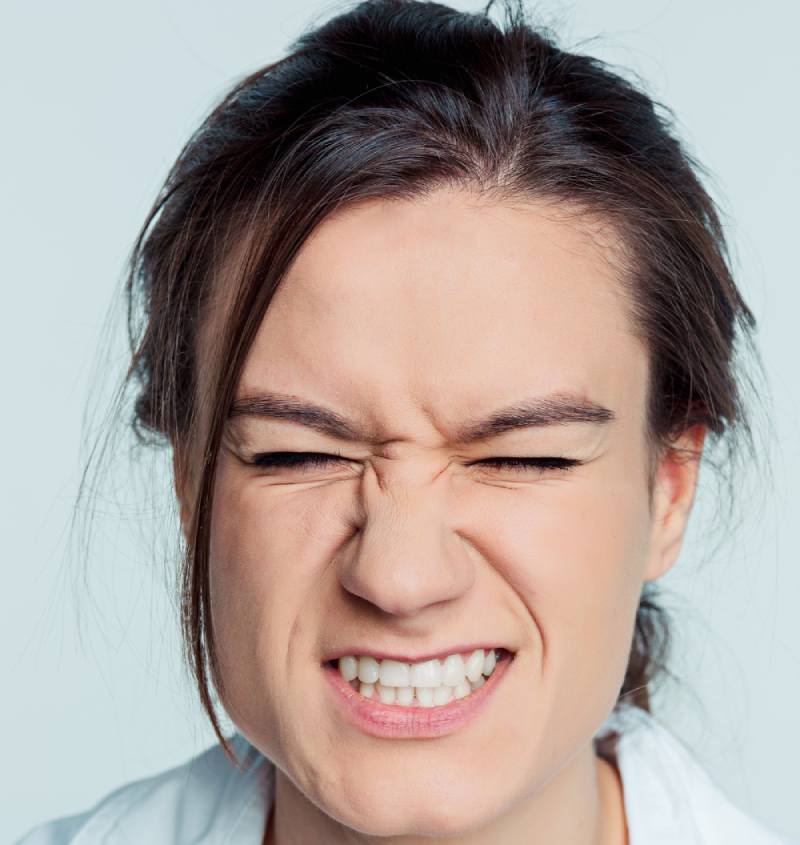 Young women in Dental clinic grimacing becuase of tooth pain